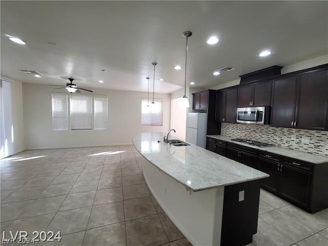 kitchen with a center island with sink, decorative light fixtures, sink, and appliances with stainless steel finishes