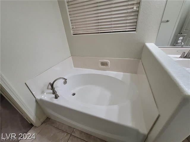 bathroom featuring tile patterned floors, a bathtub, and sink