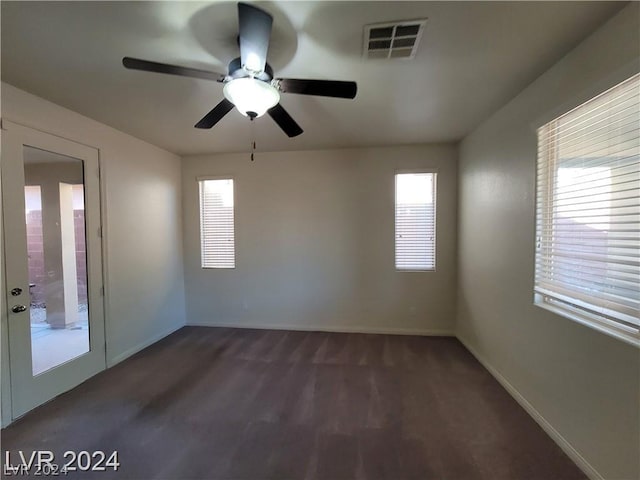 carpeted spare room featuring ceiling fan