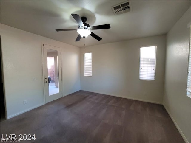 carpeted spare room featuring ceiling fan