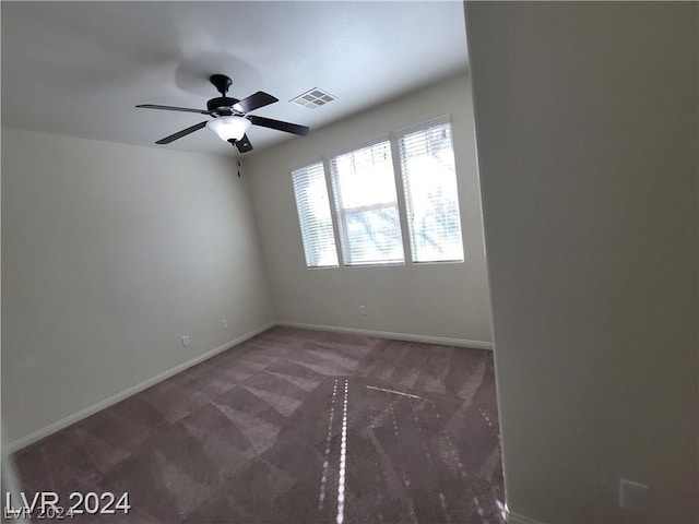 empty room with dark carpet and ceiling fan