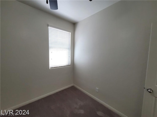 unfurnished room featuring dark carpet