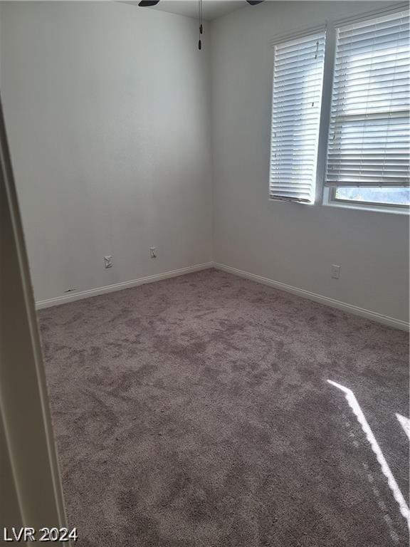 carpeted empty room featuring ceiling fan