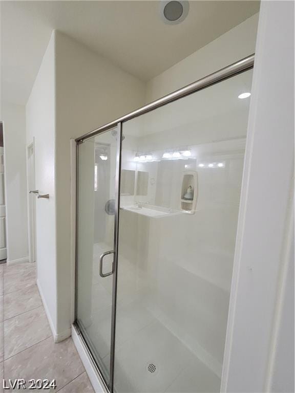 bathroom with tile patterned flooring and walk in shower