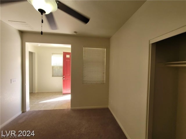 unfurnished bedroom featuring carpet flooring, a closet, and ceiling fan