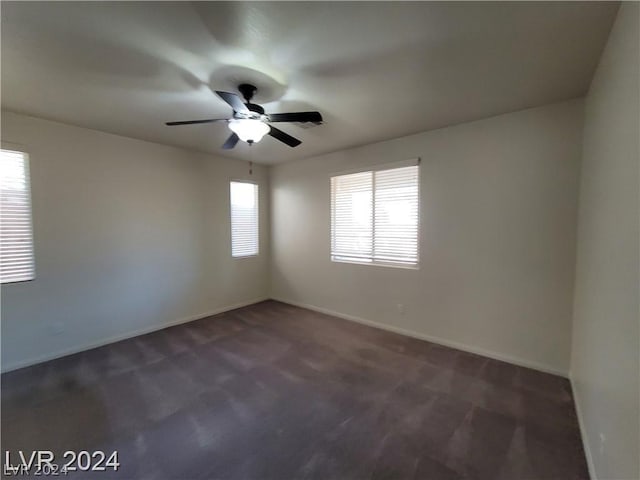 carpeted spare room featuring ceiling fan