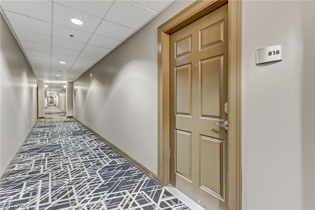 hall with a paneled ceiling