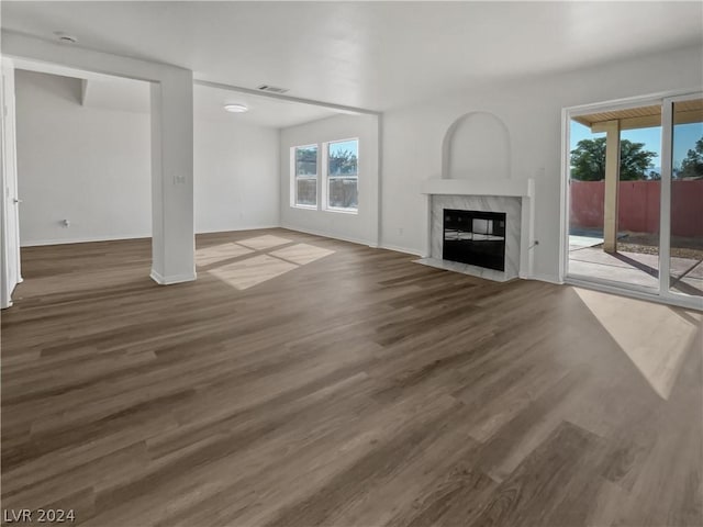 unfurnished living room featuring dark hardwood / wood-style flooring and a high end fireplace