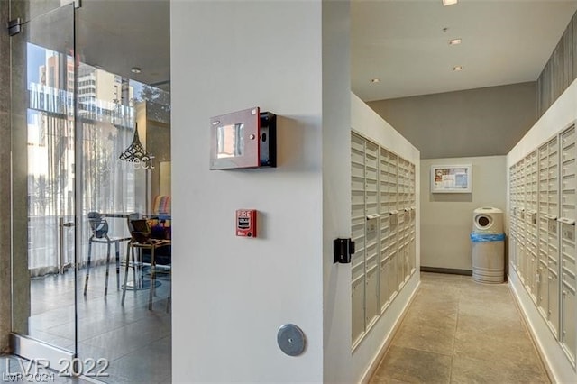 hallway featuring a mail area and light tile floors