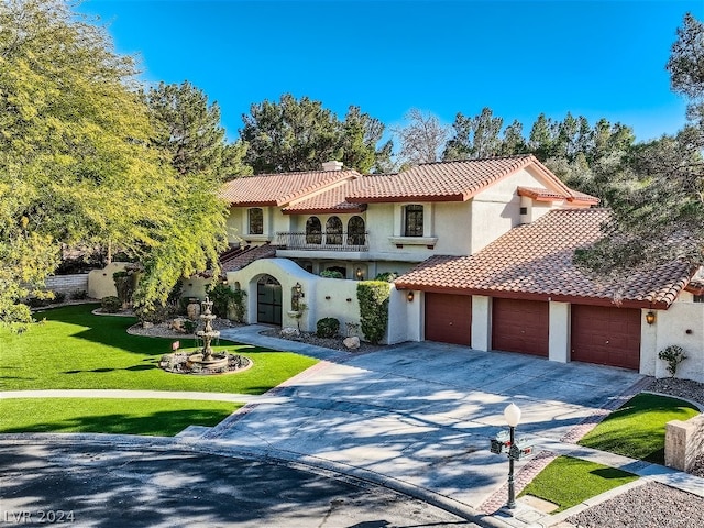 mediterranean / spanish-style house featuring a front lawn, a tile roof, stucco siding, a garage, and a balcony