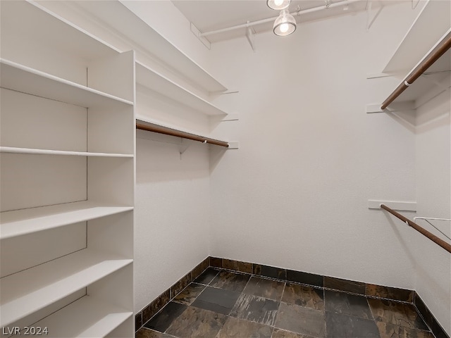 spacious closet featuring stone finish floor