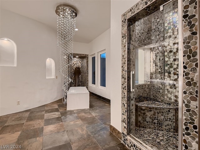 bathroom with tiled shower, a chandelier, and tile floors