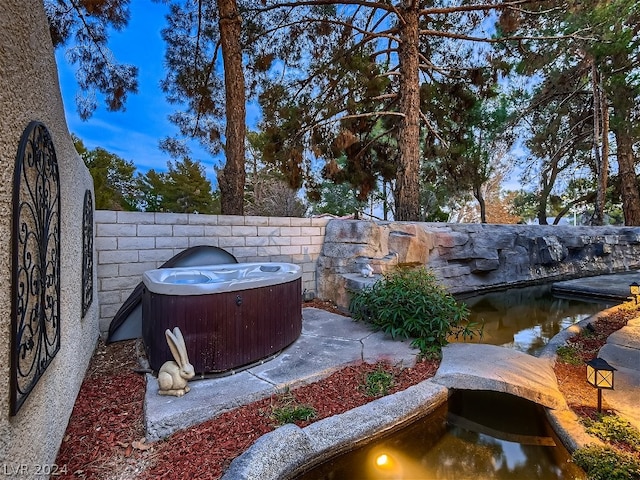 view of patio featuring a hot tub and fence