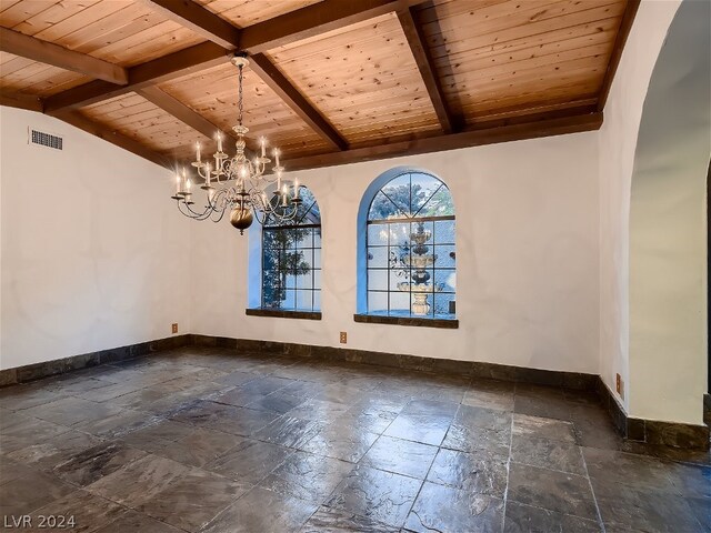 empty room featuring wood ceiling, vaulted ceiling with beams, dark tile floors, and an inviting chandelier