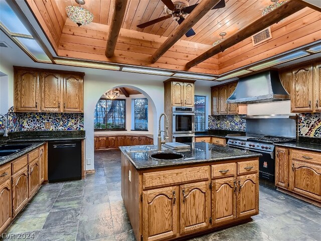 kitchen featuring backsplash, wooden ceiling, black appliances, an island with sink, and wall chimney exhaust hood