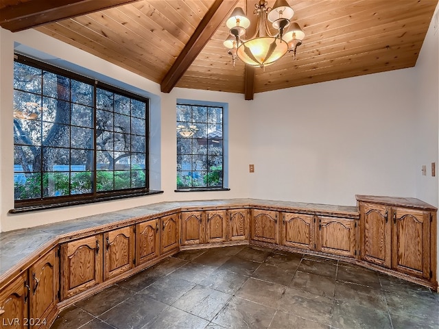 interior space with beamed ceiling, wood ceiling, dark tile floors, and an inviting chandelier