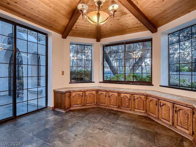 unfurnished sunroom featuring beam ceiling, a chandelier, wood ceiling, and plenty of natural light