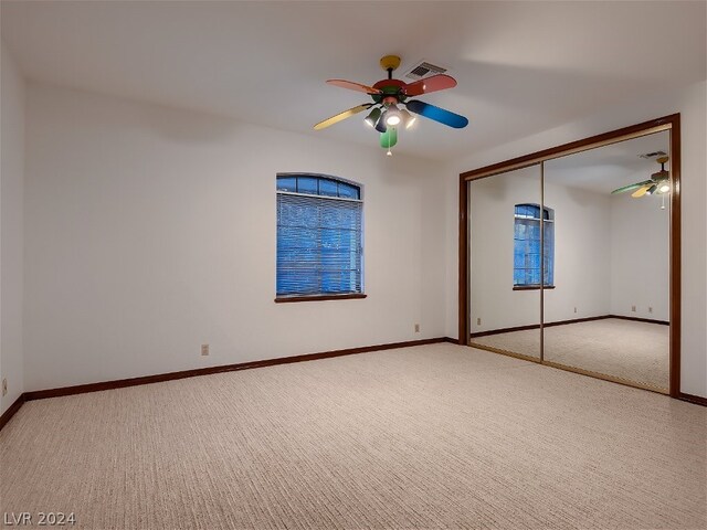 unfurnished bedroom featuring a closet, ceiling fan, and carpet floors