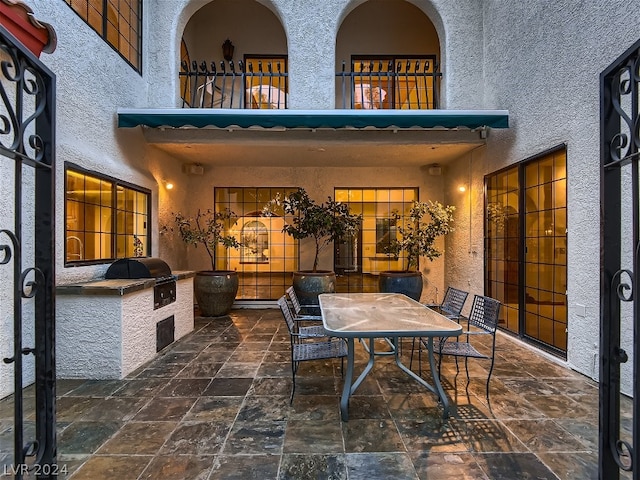 view of patio with a balcony, area for grilling, outdoor dining area, and grilling area