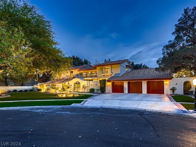 mediterranean / spanish-style house featuring a garage and a yard