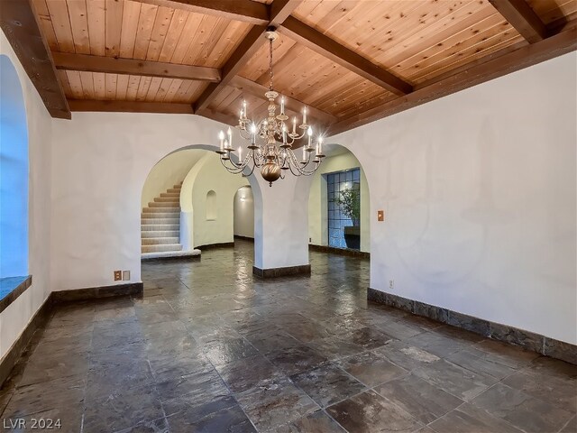 unfurnished dining area featuring vaulted ceiling with beams, baseboards, stairs, wooden ceiling, and arched walkways