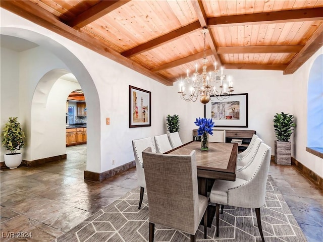 dining area with baseboards, a notable chandelier, stone tile flooring, and wooden ceiling