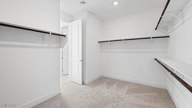 walk in closet featuring light carpet