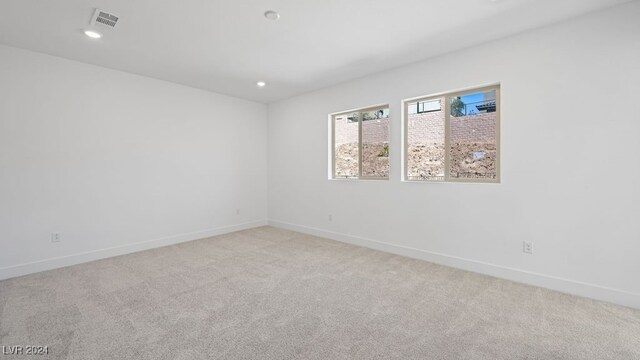 spare room featuring light colored carpet