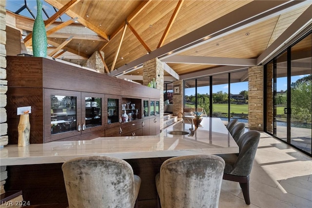 bar with high vaulted ceiling, beam ceiling, wooden ceiling, and floor to ceiling windows