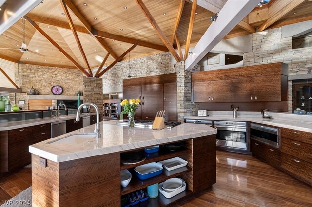 kitchen with a spacious island, dark wood-type flooring, sink, wood ceiling, and beam ceiling