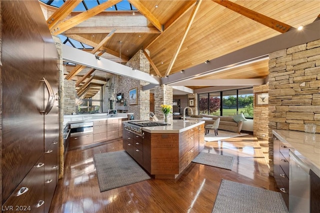 kitchen with dark hardwood / wood-style flooring, beamed ceiling, wooden ceiling, and a spacious island