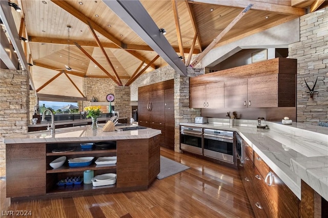 kitchen with beam ceiling, wood ceiling, high vaulted ceiling, and oven