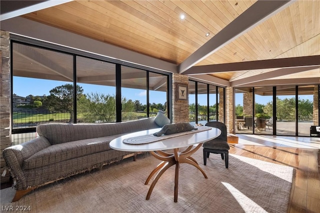 sunroom / solarium featuring vaulted ceiling, plenty of natural light, and wooden ceiling