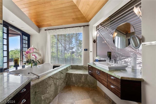 bathroom with vanity, lofted ceiling, a relaxing tiled tub, and wood ceiling