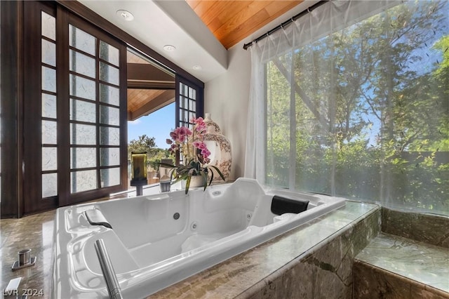 bathroom featuring tiled bath and wooden ceiling