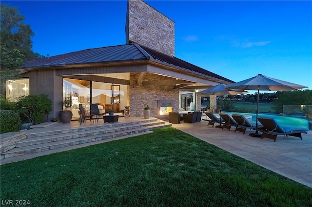 rear view of house featuring a patio, outdoor lounge area, and a yard