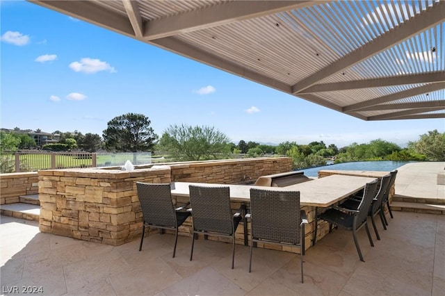 view of patio featuring exterior bar and a pergola