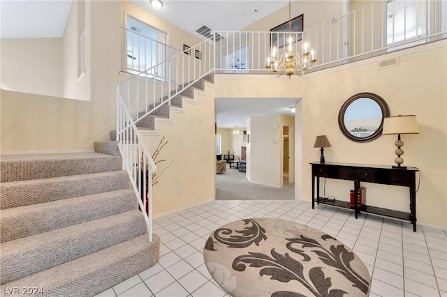 entrance foyer with light tile patterned flooring, a towering ceiling, and a chandelier