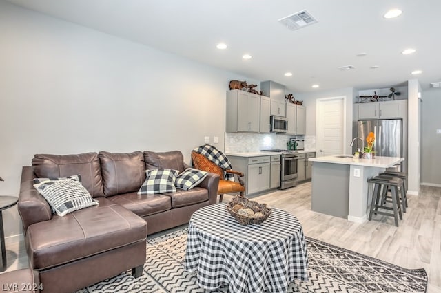 living room with sink and light hardwood / wood-style flooring