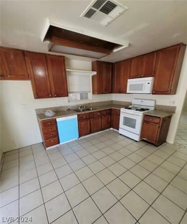 kitchen with light tile patterned floors, sink, and white appliances