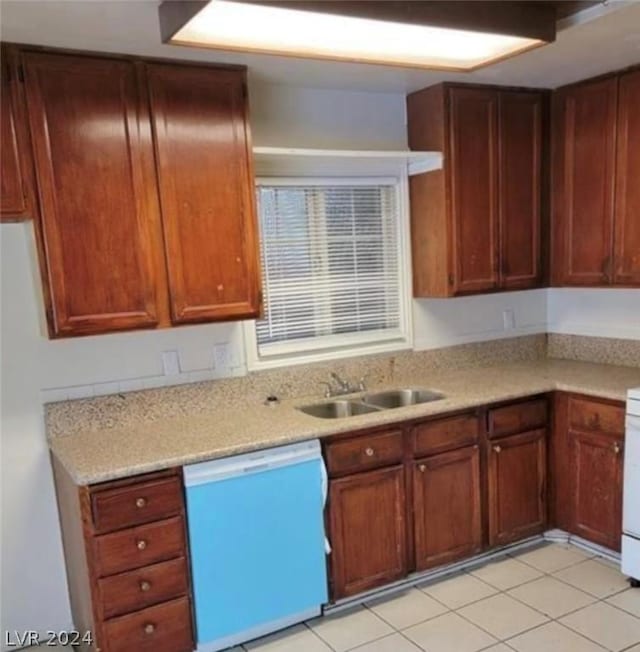 kitchen featuring light tile patterned floors, dishwasher, and sink