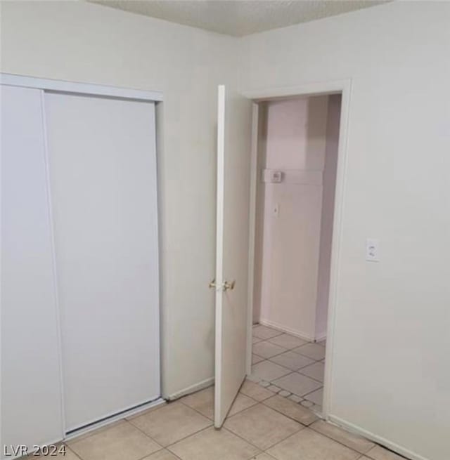 unfurnished bedroom featuring a closet and light tile patterned flooring