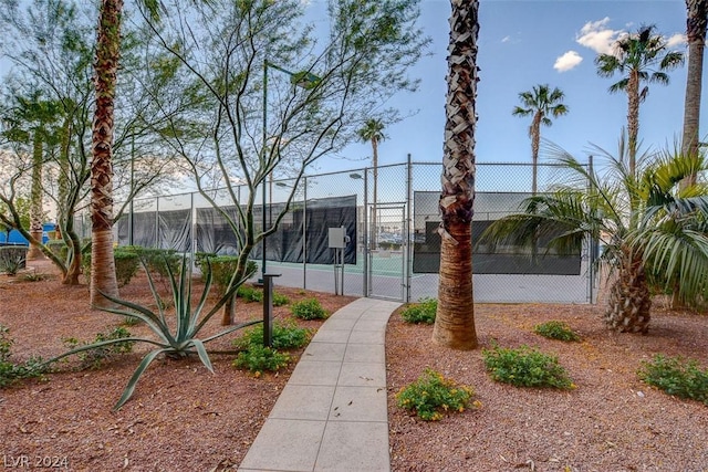 view of property's community with a tennis court, fence, and a gate