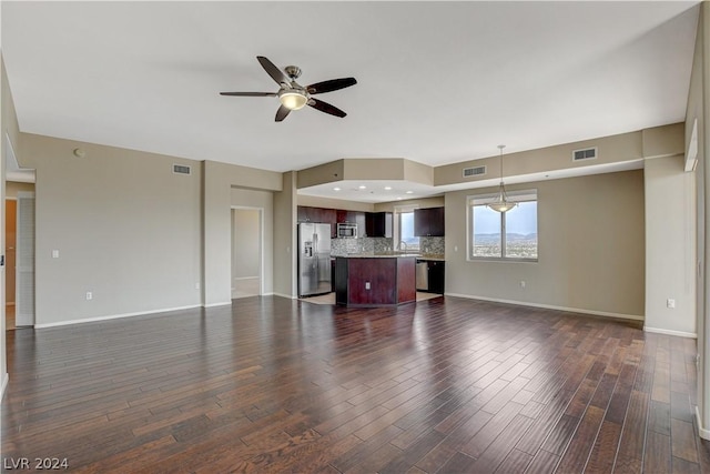 unfurnished living room featuring dark wood-style floors, visible vents, and baseboards