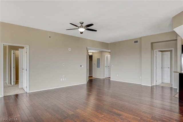 spare room with dark wood-style floors, ceiling fan, electric panel, and baseboards