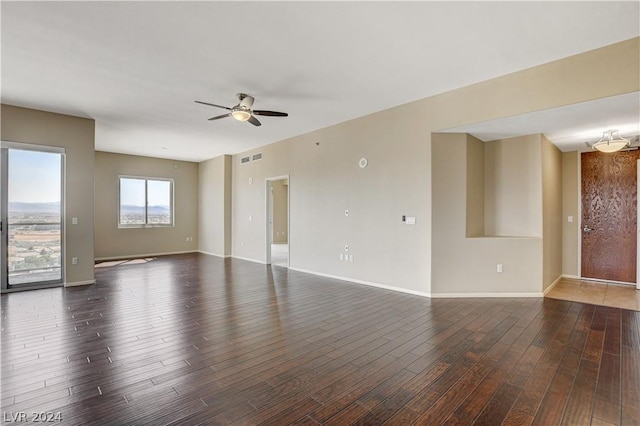 unfurnished room featuring ceiling fan, dark wood-type flooring, visible vents, and baseboards