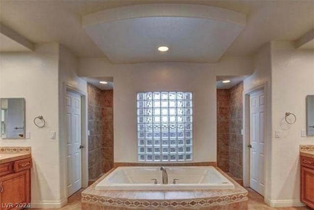 bathroom featuring tiled bath and vanity