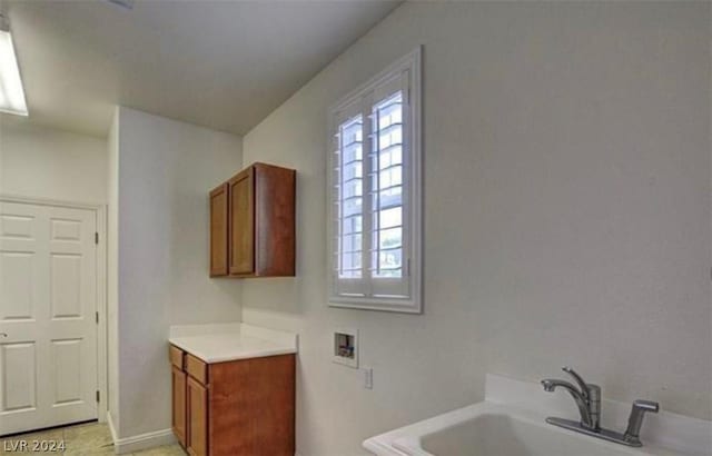 bathroom featuring tile patterned floors, a tub to relax in, and sink