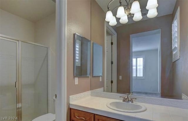 bathroom with toilet, vanity, a chandelier, and walk in shower