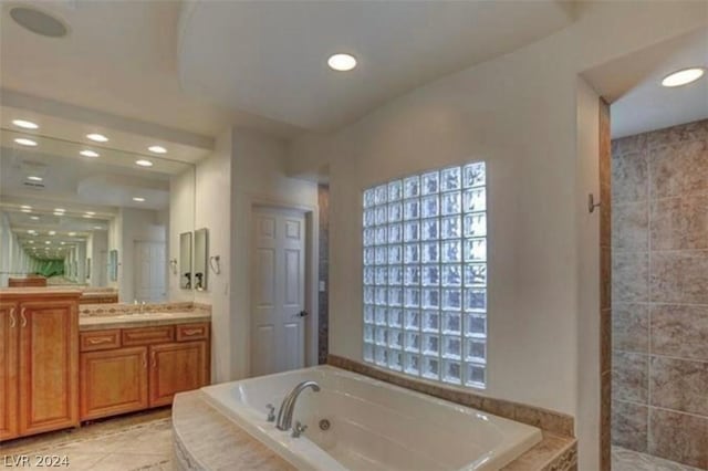 bathroom with vanity and tiled bath